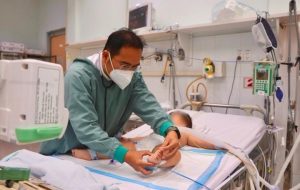 Bác sĩ khám cho trẻ tại bệnh viện trong bối cảnh số ca tay chân miệng TP.HCM gia tăng.