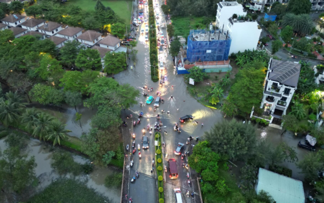 Toàn cảnh tuyến đường ở TP.HCM bị ngập nước do triều cường, phương tiện di chuyển khó khăn.